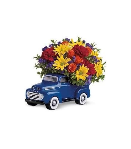 a blue truck filled with lots of colorful flowers