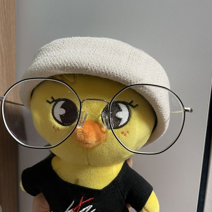 a yellow stuffed bird wearing glasses and a hat