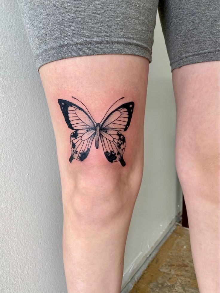 a woman's leg with a butterfly tattoo on it