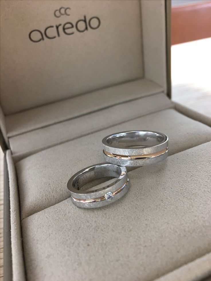 two silver wedding rings sitting in a box