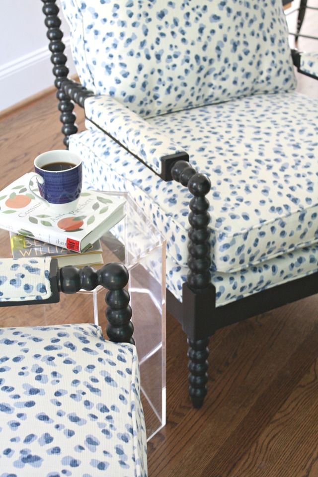 a blue and white chair sitting on top of a wooden floor next to a table