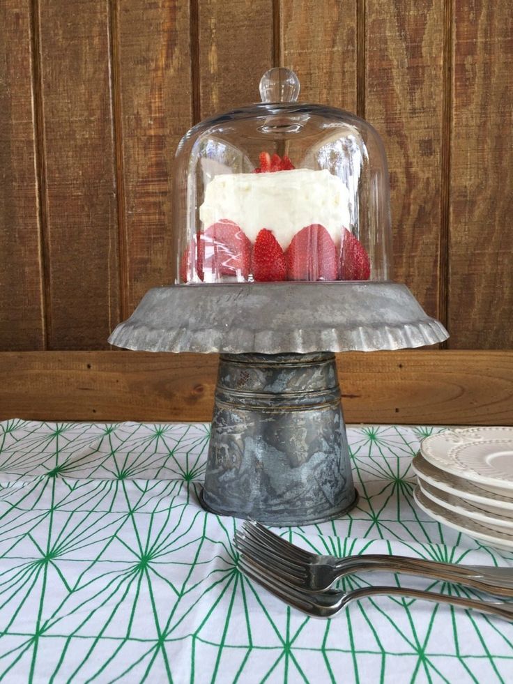 a cake under a glass dome on top of a table