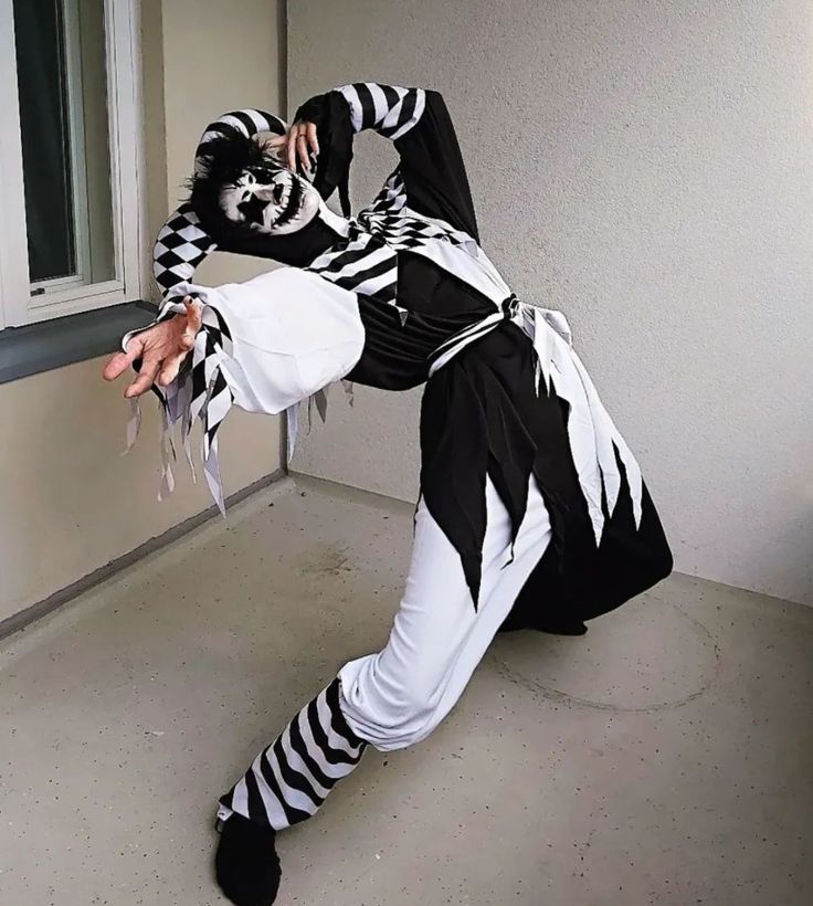 a man dressed as a skeleton dancing in front of a window with his hands on his hips