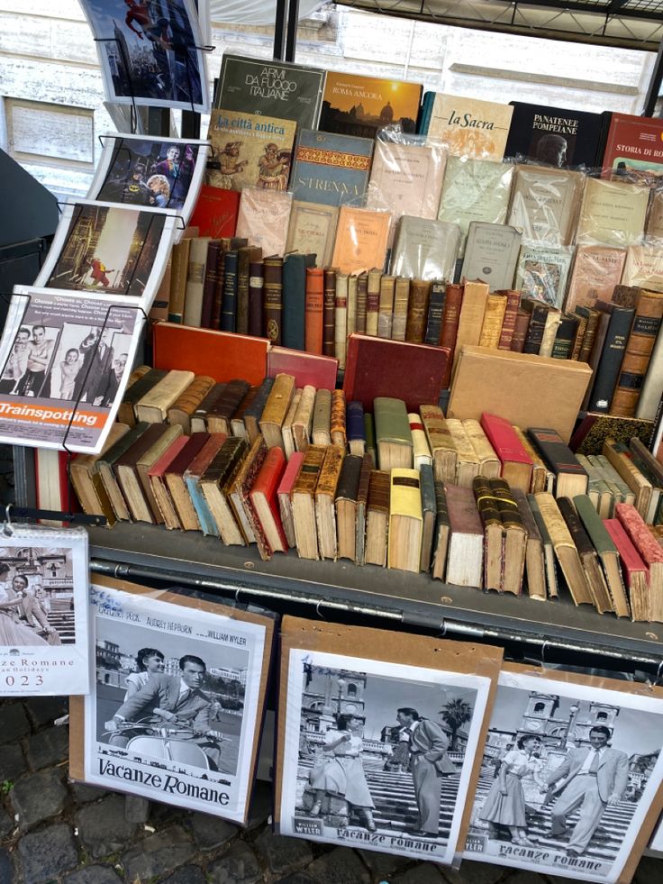 many books are stacked on top of each other in front of a store display case