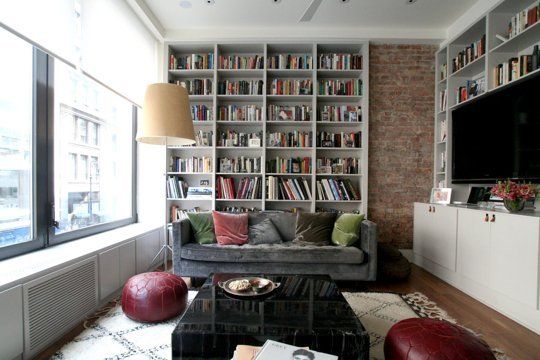 a living room filled with furniture and a flat screen tv mounted on a wall next to a window