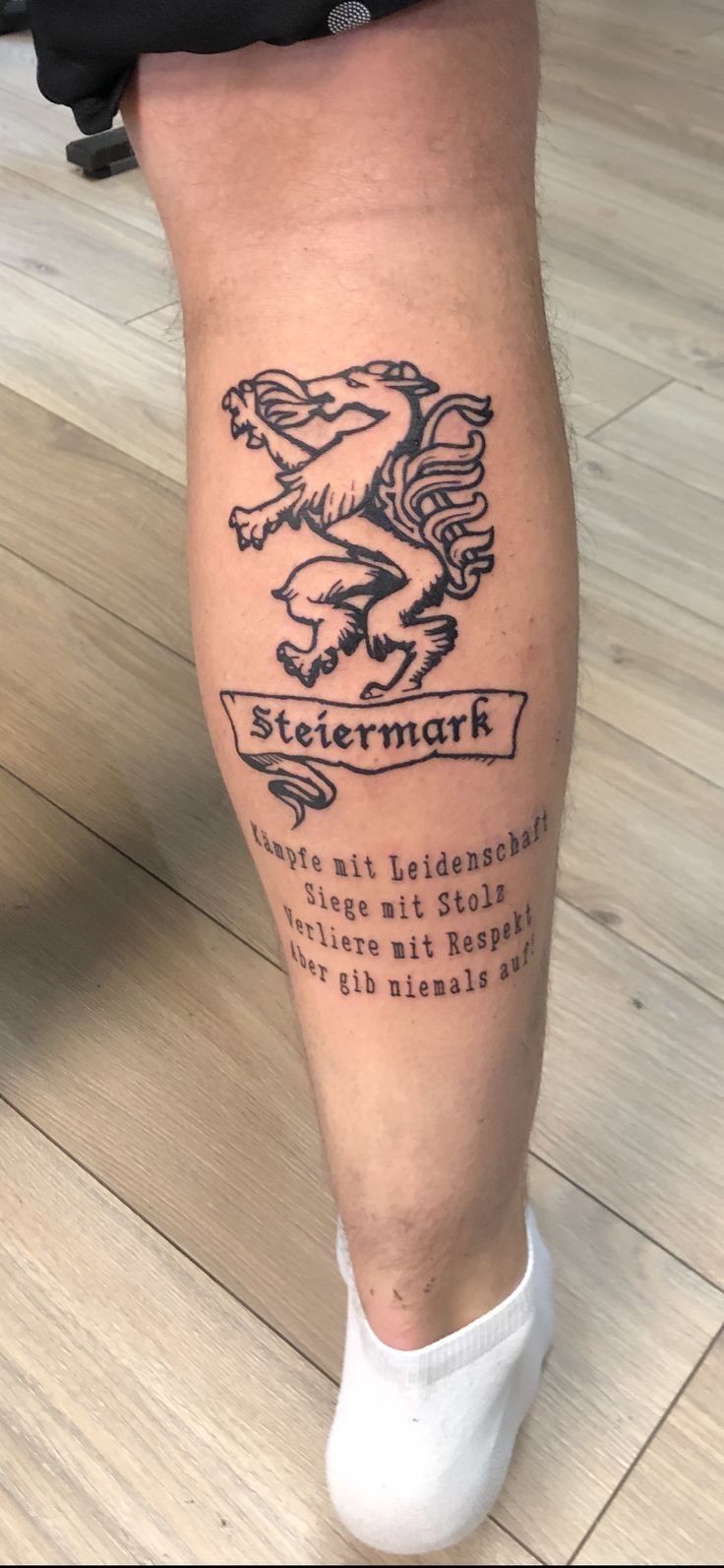 a person with a tattoo on their leg that reads steemart and has an eagle