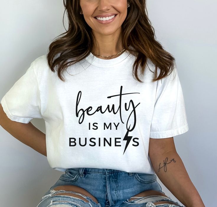 a woman wearing a t - shirt that says beauty is my business