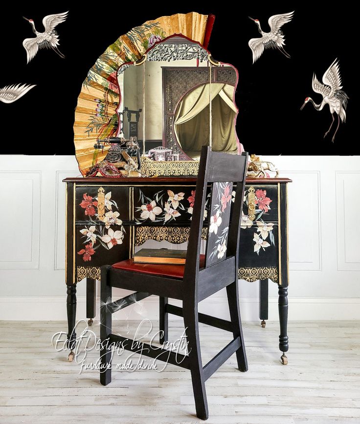 a desk with a mirror, chair and birds flying around in the air above it