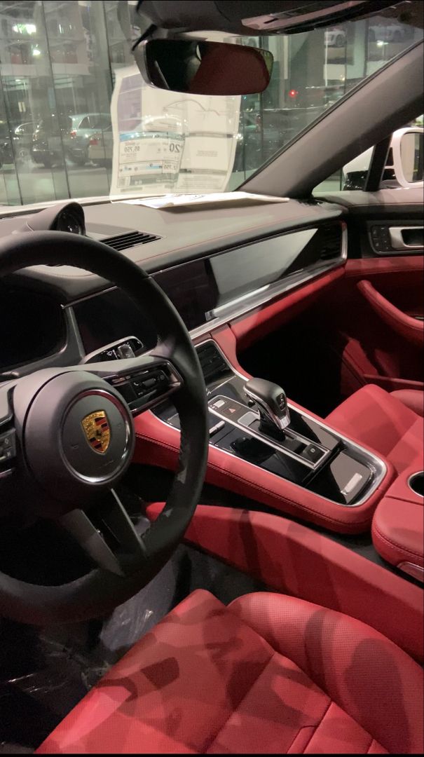 the interior of a sports car with red leather seats and steering wheel, in a showroom