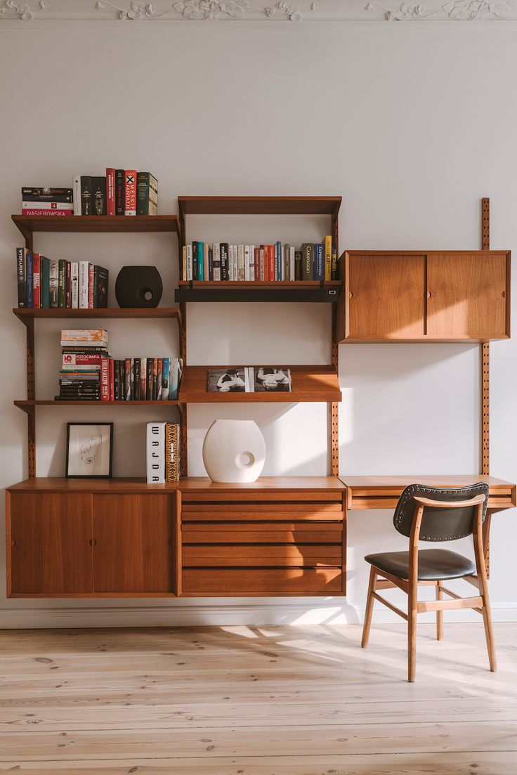 a room with a desk, bookshelf and chair next to the bookcase