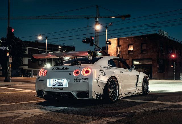 a white sports car parked on the street at night