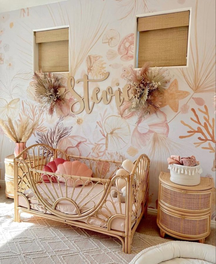 a baby's room decorated in pink and gold with flowers on the wall behind it