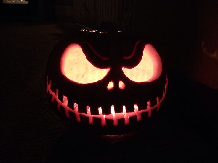 a jack - o'- lantern pumpkin with candles lit up in the shape of a face