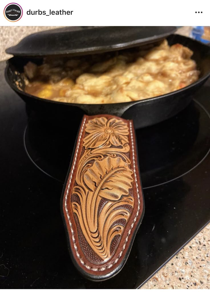 a wooden knife case sitting on top of a stove next to a skillet filled with food