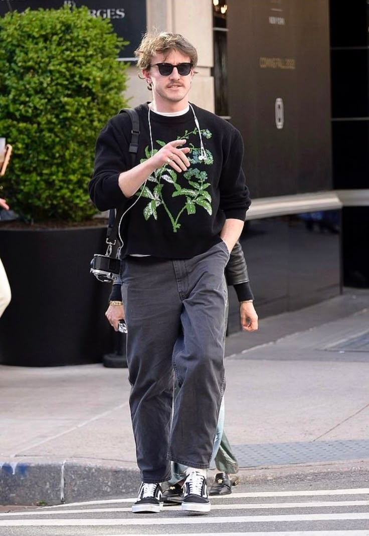 a man walking across a street while wearing headphones