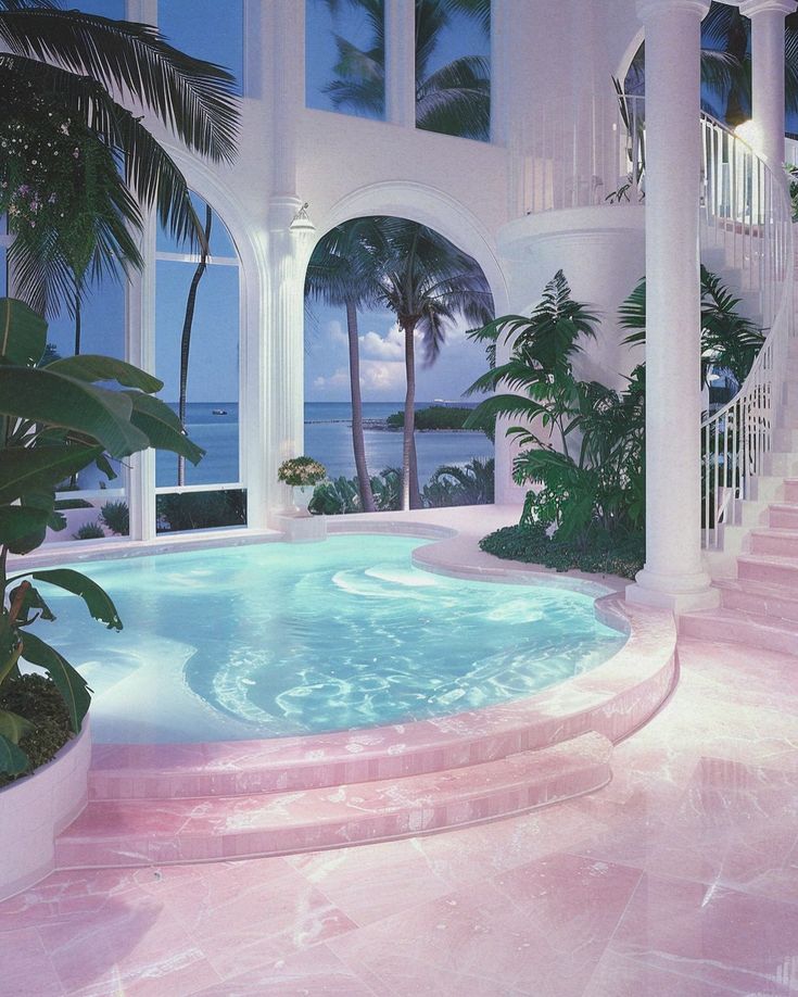 an indoor swimming pool with steps leading up to it and palm trees in the background