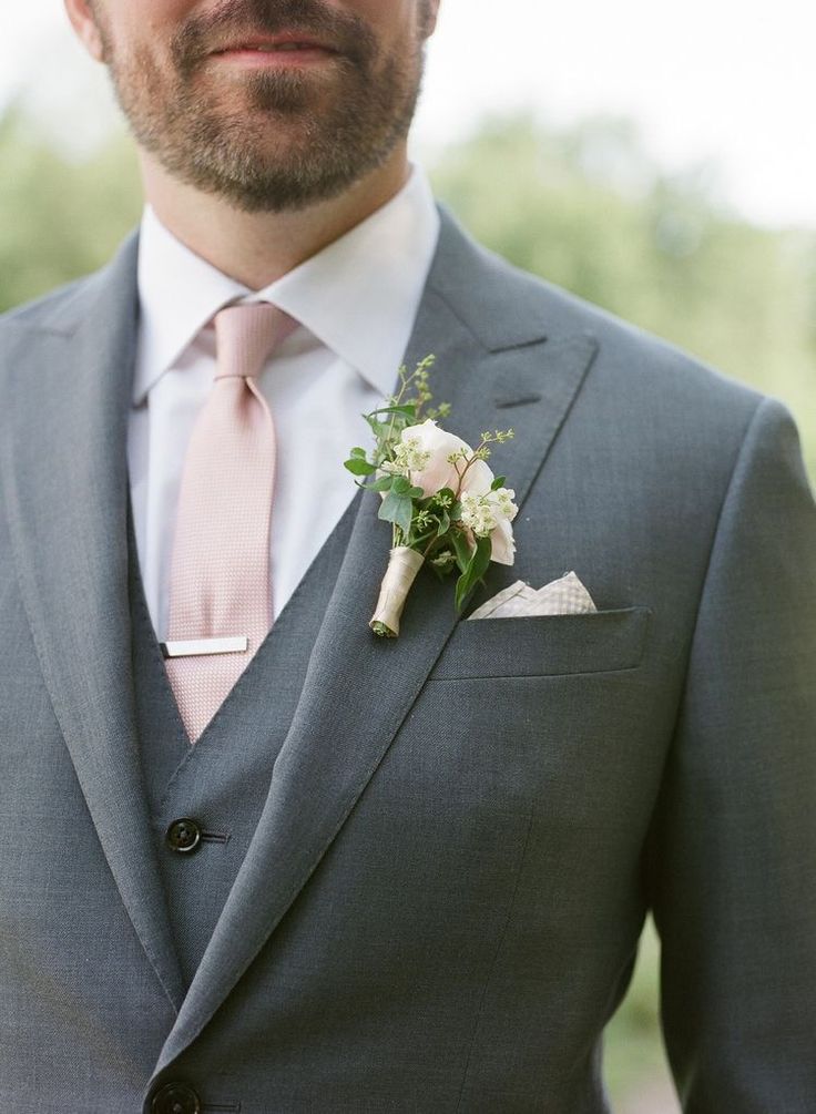 a man in a suit and tie with a boutonniere on his lapel