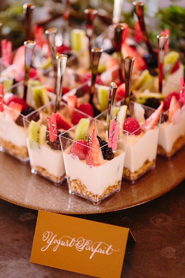 small desserts are arranged on a wooden platter