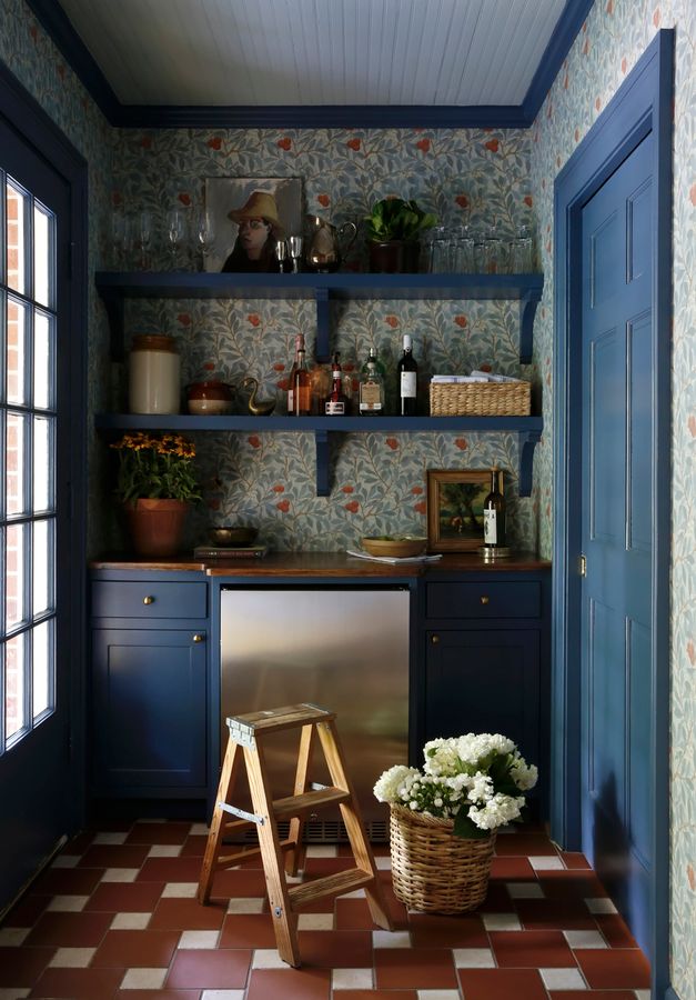 a kitchen with blue cabinets and tile flooring in the center is decorated with flowers