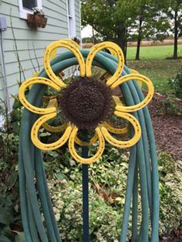 a garden hose holder with a yellow flower on it