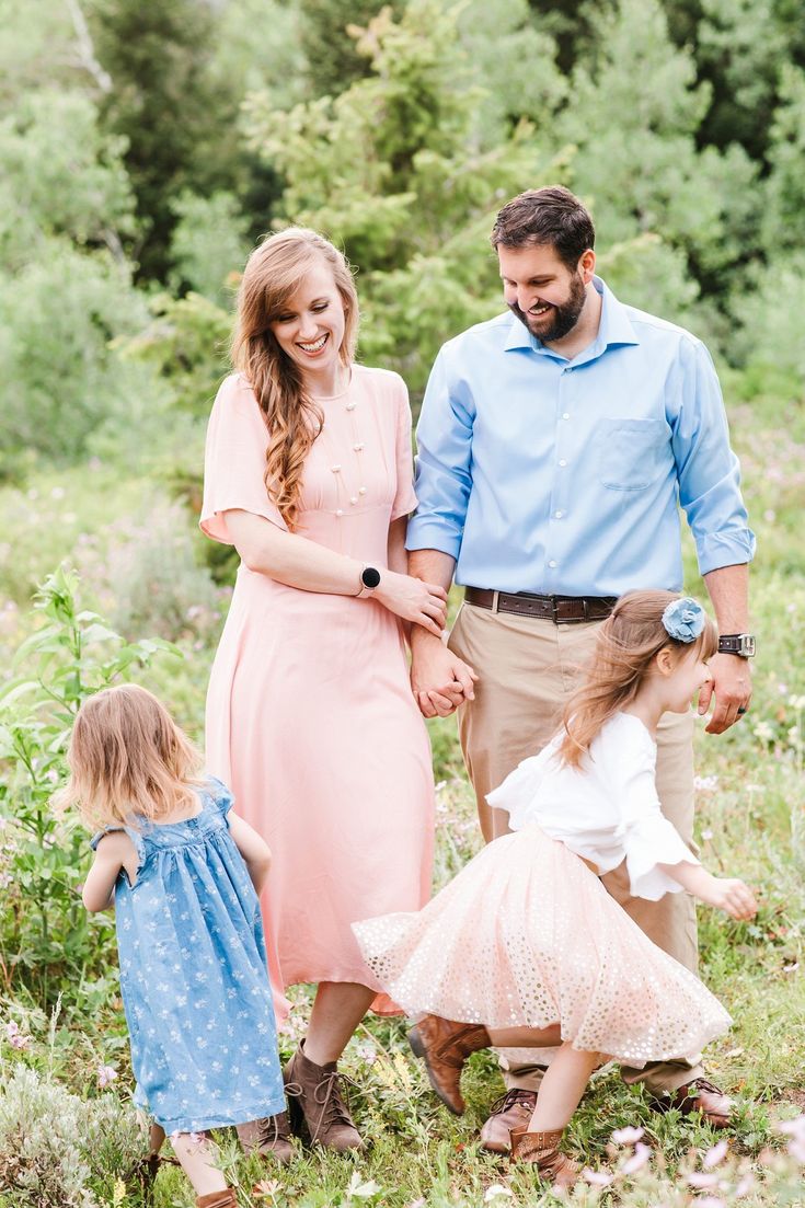 a family holding hands and walking through the woods