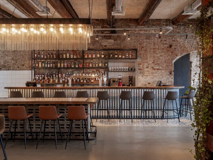 an industrial bar with stools and brick walls