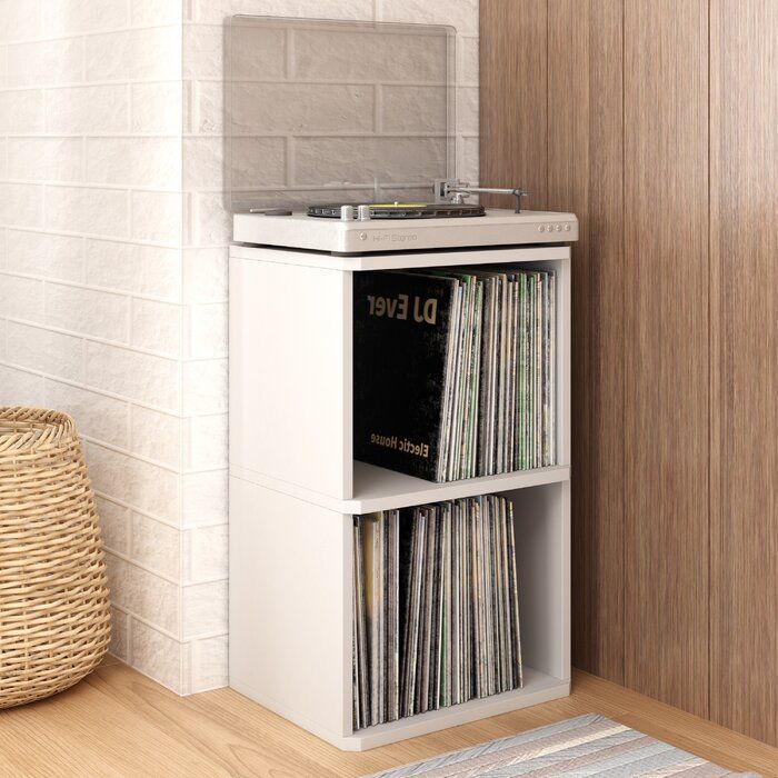 a record player sitting on top of a wooden shelf next to a basket filled with records