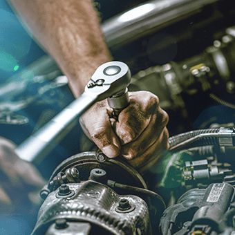 a man is working on an engine in his car's engine bay, while holding the wrench