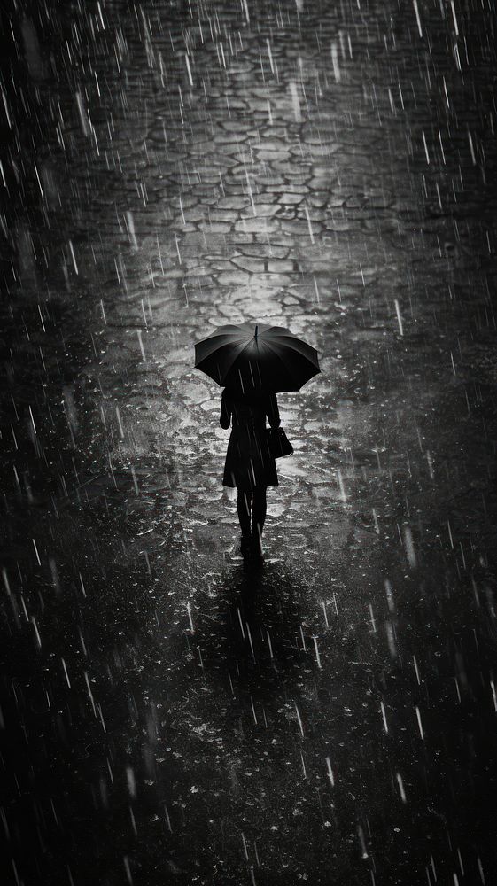 a person walking in the rain with an umbrella over their head while it's raining