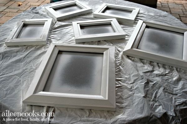 four white frames sitting on top of a table covered in plastic