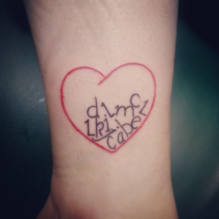 a heart shaped tattoo with words written on it