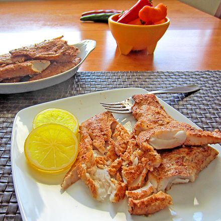 the meal is ready to be eaten on the table with lemons and tomatoes in the background