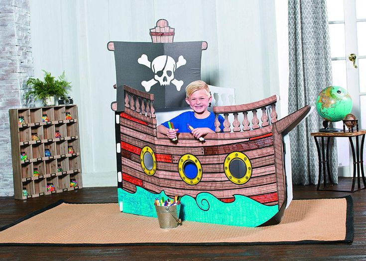 a child in a pirate ship chair made out of cardboard