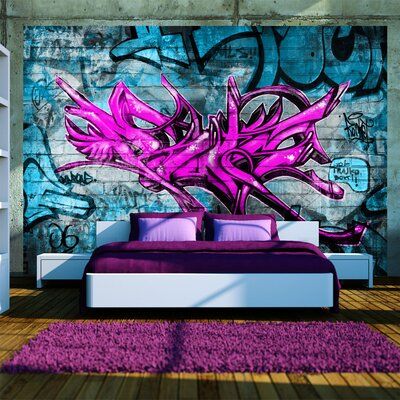 a bedroom with graffiti on the wall and purple bedding