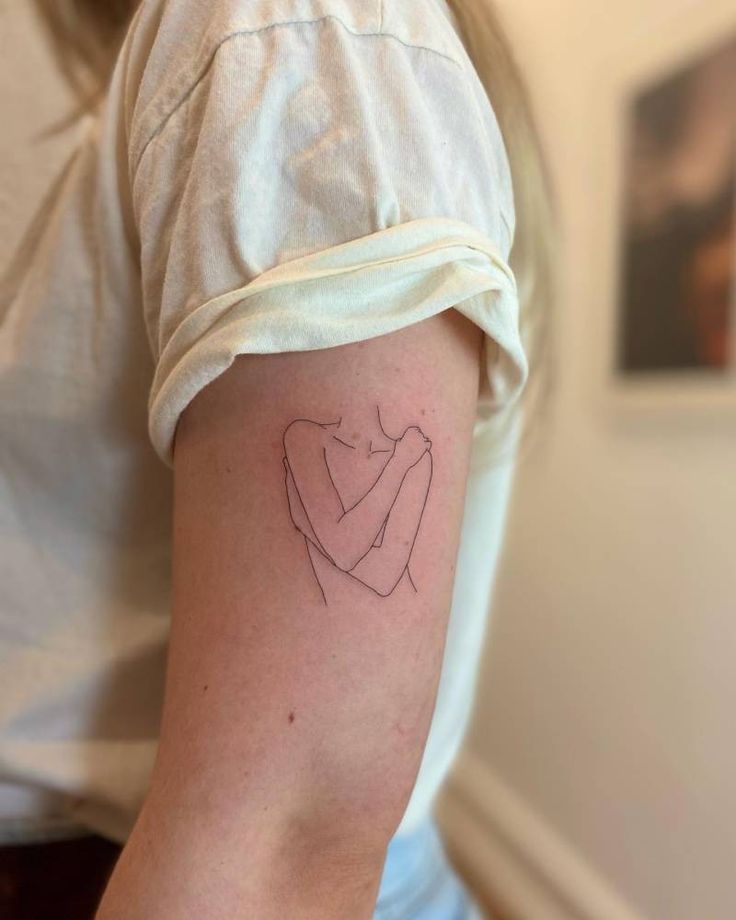 a woman with a tattoo on her arm holding a small heart in the shape of a hand