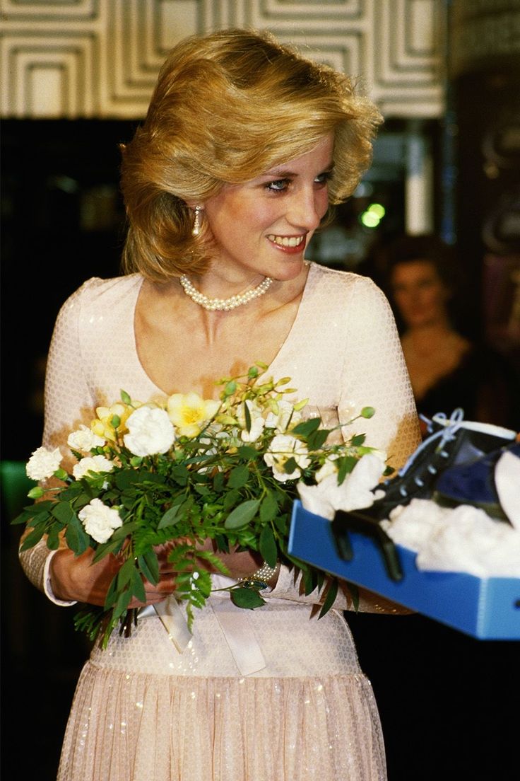 the woman is holding a bouquet of flowers in her hand and smiling at someone else