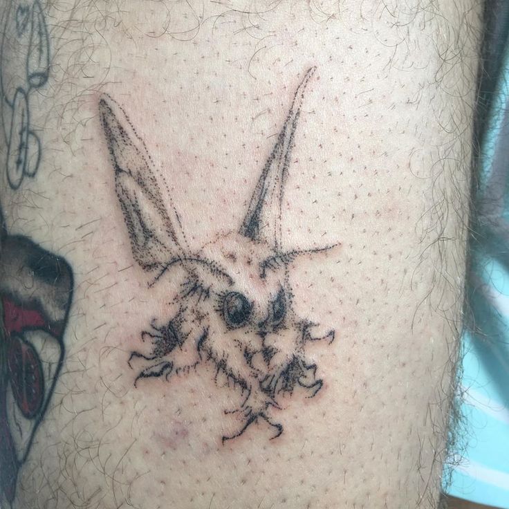 a close up of a person's leg with a rabbit tattoo on the side