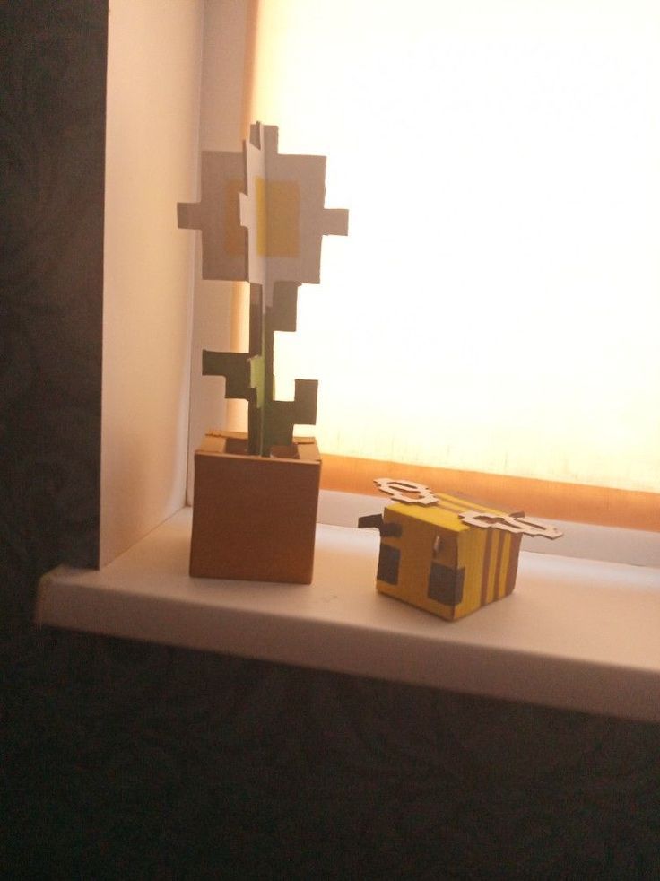 a yellow box sitting on top of a window sill next to a small tree