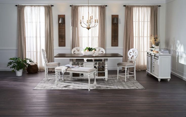 a dining room table with white chairs and a chandelier