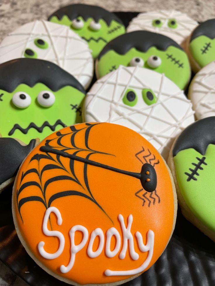 some decorated cookies are on a plate with spooky eyes and spider webs