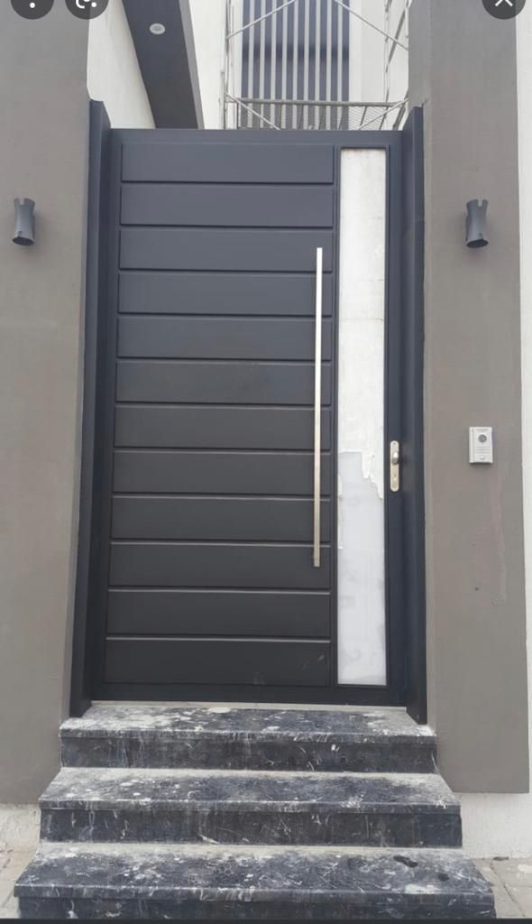 the front door to a house with steps leading up to it and an iron gate