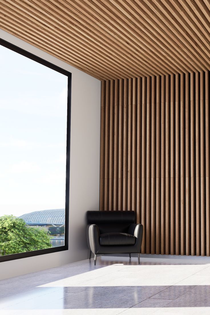 a black chair sitting in front of a window next to a wooden wall with vertical slats on it