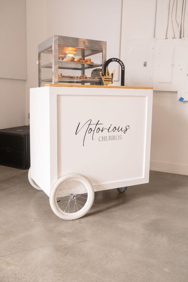 an ice cream cart with wheels on the floor