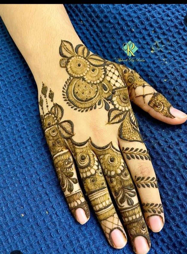 a woman's hand with henna tattoos on it