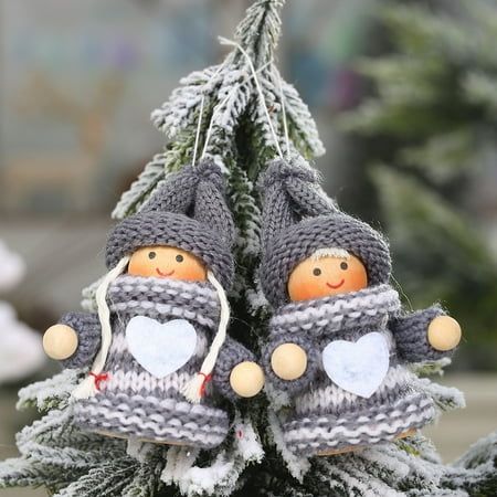 two knitted dolls are sitting on top of a small christmas tree in the snow