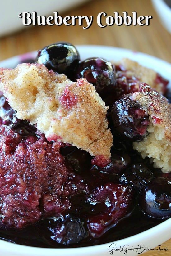 blueberry cobbler in a white bowl on a wooden table