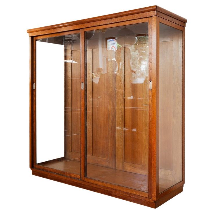 a wooden display case with glass doors on the front and bottom sides, holding two empty bottles