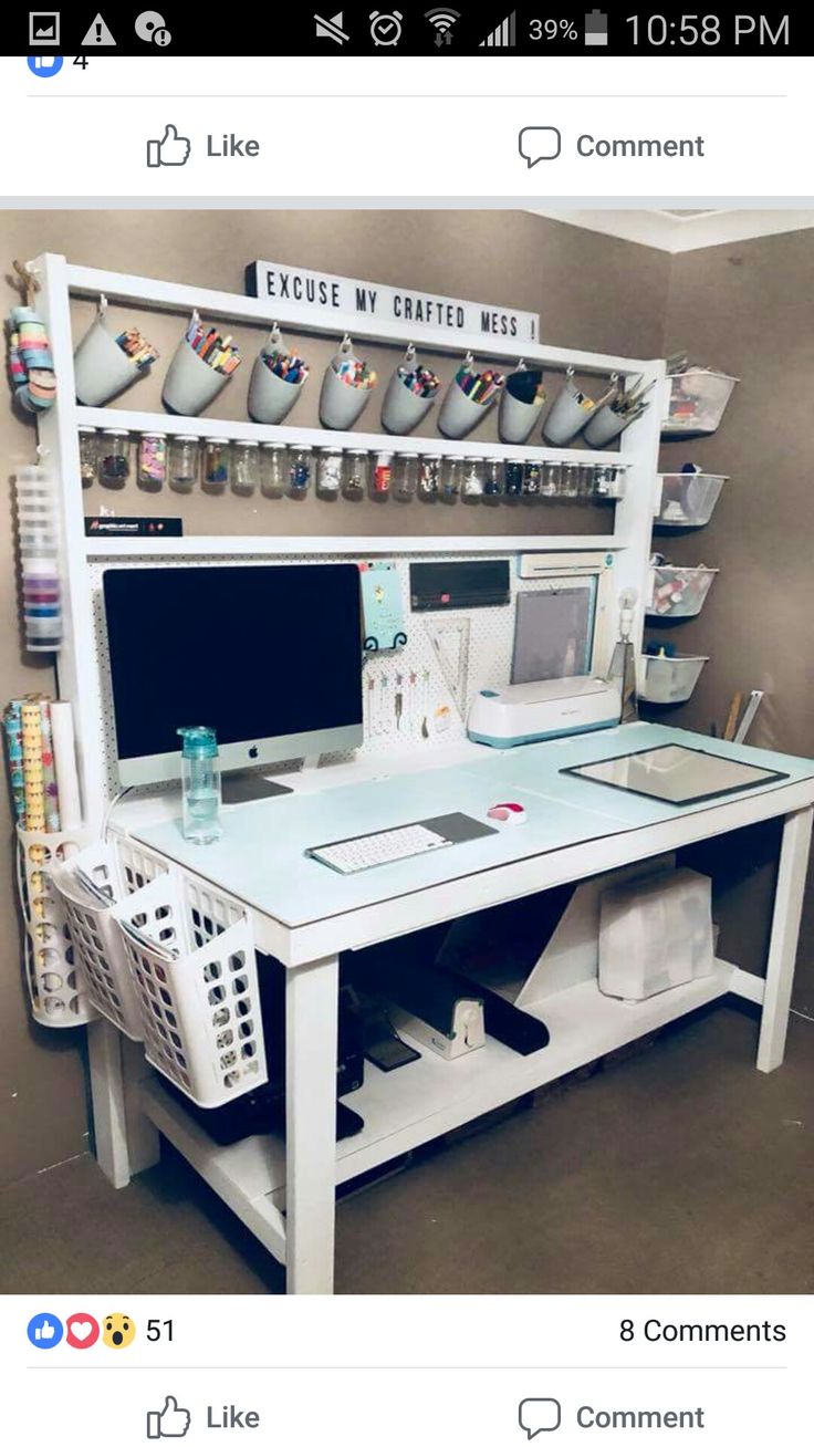 a white desk with a computer on it and lots of cups hanging from the wall