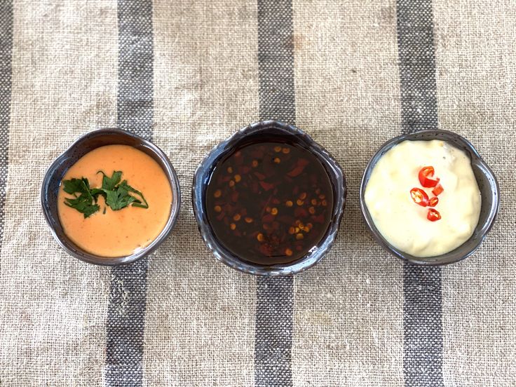 three different types of sauces in small bowls