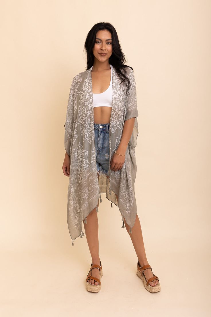 Update your vacation wardrobe with the stylish Mandala Tassel Kimono. This cute kimono will give you a cool, trendy look that's perfect for any beach destination or sunny getaway. Whether you pair it up with simple shorts or show off your feminine shape with a skirt, this kimono is sure to make you look and feel completely adorable. Showcasing beautiful colors and tassels, the Mandala Tassel Kimono is definitely the quintessential must-have item of the season! #lovemyleto 100% Viscose Imported Bohemian Lightweight Cover-up For Day Out, One Size Long Cover-up For Day Out, Chic Summer Wrap Cover-up, Vacation Beach Cover-up Kimono With Kimono Sleeves, Lightweight Wrap Beach Cover-up, Summer Wrap Cover-up Free Size, Long Tasseled Kimono For Vacation, Long Tasseled Kimono For Beach Cover-up, Open Front Beach Kimono With Tassels